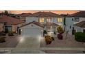 Two-story home with a two-car garage, tiled roof, and well-maintained landscaping at sunset at 3144 W Maya Way, Phoenix, AZ 85083