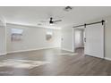 Spacious living room featuring hard surface floors, a ceiling fan, and a sliding barn door at 325 W Angus Rd, San Tan Valley, AZ 85143