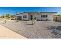 Contemporary home showcasing minimalist xeriscaping with a chic, dark gray garage door and modern design elements at 3939 E Sahuaro Dr, Phoenix, AZ 85028