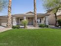 Beautifully landscaped front yard with green grass and desert plants at 42476 W Chisholm Dr, Maricopa, AZ 85138