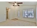 Inviting living room with neutral carpet, a ceiling fan, a window, and easy access to other rooms at 44917 W Zion Rd, Maricopa, AZ 85139