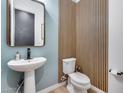 Chic powder bathroom with a pedestal sink, wood accent wall and wood-look flooring at 4606 S Ferric --, Mesa, AZ 85212