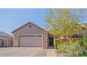 Inviting single-story home featuring a brick-paved driveway and mature tree in the front yard at 560 S 197Th Ave, Buckeye, AZ 85326