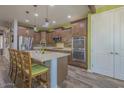 Spacious kitchen featuring an island with bar seating, stainless steel appliances, and wooden cabinets at 560 S 197Th Ave, Buckeye, AZ 85326