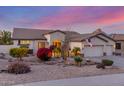 Attractive single-story home showcasing desert landscaping, an American flag, and a three-car garage at 6022 W Fetlock Trl, Phoenix, AZ 85083