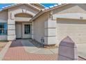Close up of a home's entrance and garage, showcasing the brick-paved walkway and neutral color scheme at 6904 W Golden Ln, Peoria, AZ 85345