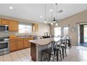 Open kitchen with stainless steel appliances, center island, and adjacent dining area with backyard access at 6904 W Golden Ln, Peoria, AZ 85345