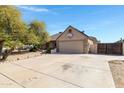 Suburban home featuring a spacious concrete driveway, attached two-car garage, and mature landscaping at 6909 W Cherry Hills Dr, Peoria, AZ 85345