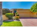 Beautiful home featuring a 2-car garage, well-manicured lawn, and a second-story balcony, enhancing its curb appeal at 7330 E Palo Verde Dr # 1, Scottsdale, AZ 85250