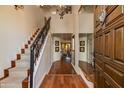 Grand foyer features a winding staircase, wood flooring, and decorative mirrors, exuding elegance and sophistication at 7330 E Palo Verde Dr # 1, Scottsdale, AZ 85250