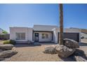 Single-story home with desert landscaping, rock accents, and a two-car garage at 801 E Piute Ave, Phoenix, AZ 85024