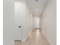 Hallway featuring hardwood floors, white walls, doors and trim, leading to the front door at 816 E Amberwood Dr, Phoenix, AZ 85048