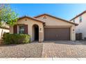 Inviting single-story home with a brick driveway, desert landscaping, and cozy front entrance, creating a welcoming curb appeal at 8515 W Peppertree Ln, Glendale, AZ 85305