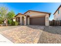 Attractive single-story home featuring low-maintenance desert landscaping and a brick-paved driveway, offering easy curb appeal at 8515 W Peppertree Ln, Glendale, AZ 85305