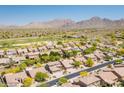 Expansive aerial shot capturing a desert community with lush landscaping and mountain views at 10558 E Meadowhill Dr, Scottsdale, AZ 85255