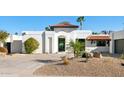 Contemporary white home with a red tile roof, desert landscaping and an arched entryway at 10905 E San Salvador Dr, Scottsdale, AZ 85259