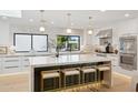 Bright kitchen with island, marble counters, pendant lighting, and stainless appliances at 10905 E San Salvador Dr, Scottsdale, AZ 85259