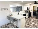 Well-lit kitchen featuring a breakfast bar, modern appliances, and stylish wood-look floors at 1132 S 81St Pl, Mesa, AZ 85208