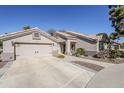 Charming home with a desert-landscaped yard, concrete driveway, and a neutral-colored exterior at 17254 N White Cloud Cir, Surprise, AZ 85374