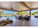 Spacious covered patio with ample seating, ceiling fans, and views of the pool and golf course at 19793 N Tapestry Ct, Surprise, AZ 85374