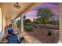 A cozy covered patio with comfortable outdoor seating, offering a relaxing view of the landscaped backyard at 23123 N Cardenas Dr, Sun City West, AZ 85375