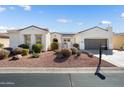 Beautiful single-story home with desert landscaping, solar panels, and an attached two car garage at 23123 N Cardenas Dr, Sun City West, AZ 85375