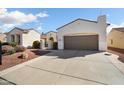 Exterior shot of the home displaying the front yard landscaping, walkway, and attached two car garage at 23123 N Cardenas Dr, Sun City West, AZ 85375