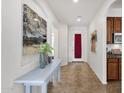 Bright hallway with decorative art, tile flooring, and access to kitchen at 2417 W Apache Rain Rd, Phoenix, AZ 85085