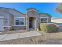 Inviting home featuring a beautiful stone entryway, a desert landscape yard, and a cozy feel at 30116 W Fairmount Ave, Buckeye, AZ 85396