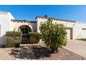 Charming single-story house with decorative ironwork, white stucco, and a lush, green citrus tree in the front yard at 322 W Laguna Dr, Tempe, AZ 85282