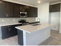 Modern kitchen featuring dark wood cabinets, an island, stainless steel appliances, and tile backsplash at 4517 S Mole --, Mesa, AZ 85212