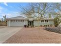 Inviting single-story home featuring desert landscaping with flowers and an attached two-car garage at 5165 E Tunder Dr, Phoenix, AZ 85044