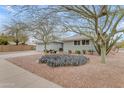 Attractive single-story home with a well-maintained yard, desert landscaping, and a two-car garage at 5165 E Tunder Dr, Phoenix, AZ 85044