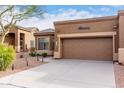 Lovely home featuring a two-car garage and a desert-style landscape with native plants at 7195 E Canyon Wren Dr, Gold Canyon, AZ 85118