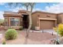 Inviting desert home featuring a lovely garden, a tiled roof, and attached two-car garage at 7195 E Canyon Wren Dr, Gold Canyon, AZ 85118