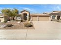 Well-manicured front yard with desert landscaping and a spacious driveway leading to a two-car garage at 7444 E Sand Hills Rd, Scottsdale, AZ 85255