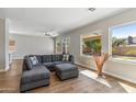 Cozy living room featuring a gray sectional sofa, hardwood floors, and backyard views at 7919 E Posada Ave, Mesa, AZ 85212