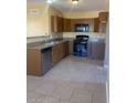 A kitchen featuring brown cabinets, granite countertops, and a tile floor at 813 N Trekell Rd, Casa Grande, AZ 85122