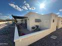 The rear exterior showcases an outdoor patio, BBQ grill, and low-maintenance desert landscaping at 877 E Lancaster Cir, Florence, AZ 85132