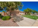 View of a landscaped front yard with desert accents and a lush green lawn at 9420 E Plata Ave, Mesa, AZ 85212