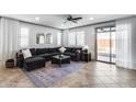 Bright living room with tile flooring, large sofa, and glass doors leading to the backyard at 9742 W Los Gatos Dr, Peoria, AZ 85383