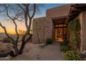 Charming front entrance with mature trees, stone accents and landscaped front yard at 9904 E Lookout Mountain Dr, Scottsdale, AZ 85262