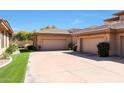 Wide driveway leading to two-car garages with beautiful desert landscaping and well-kept lawn at 15240 N Clubgate Dr # 162, Scottsdale, AZ 85254