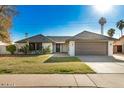 Attractive one-story home with a manicured lawn, palm trees, and an attached garage at 1531 W Naranja Ave, Mesa, AZ 85202