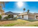 Alluring single-story home featuring a manicured lawn, palm trees, and an attached two-car garage at 1531 W Naranja Ave, Mesa, AZ 85202