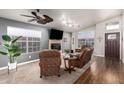 Cozy living room with stone fireplace, ceiling fan, and abundant natural light from large windows at 1710 W Winchester Way, Chandler, AZ 85286