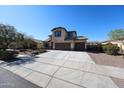 Expansive driveway leading to a neutral colored two-story home with a 3-car garage, and desert landscaping at 17531 W Hedgehog Pl, Surprise, AZ 85387