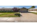 Charming single-story home featuring a manicured lawn, mature landscaping, and a two-car garage at 18835 N Mayan Dr, Sun City, AZ 85373