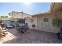 Outdoor patio with brick pavers, seating, umbrella-covered table, and neutral tones at 18835 N Mayan Dr, Sun City, AZ 85373