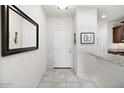 Welcoming entryway with neutral tones, a large mirror, and tile flooring at 21232 N 262Nd Dr, Buckeye, AZ 85396